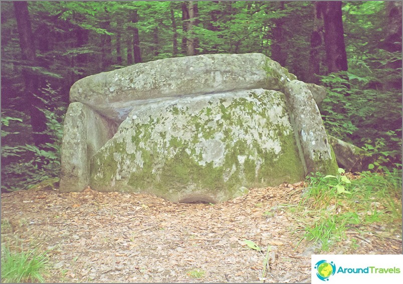 Dolmen ingrown into the ground and slipping into a precipice