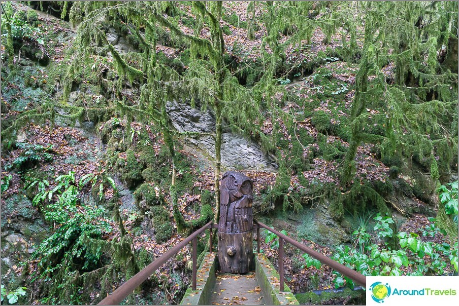 Near the entrance are several wooden figures.