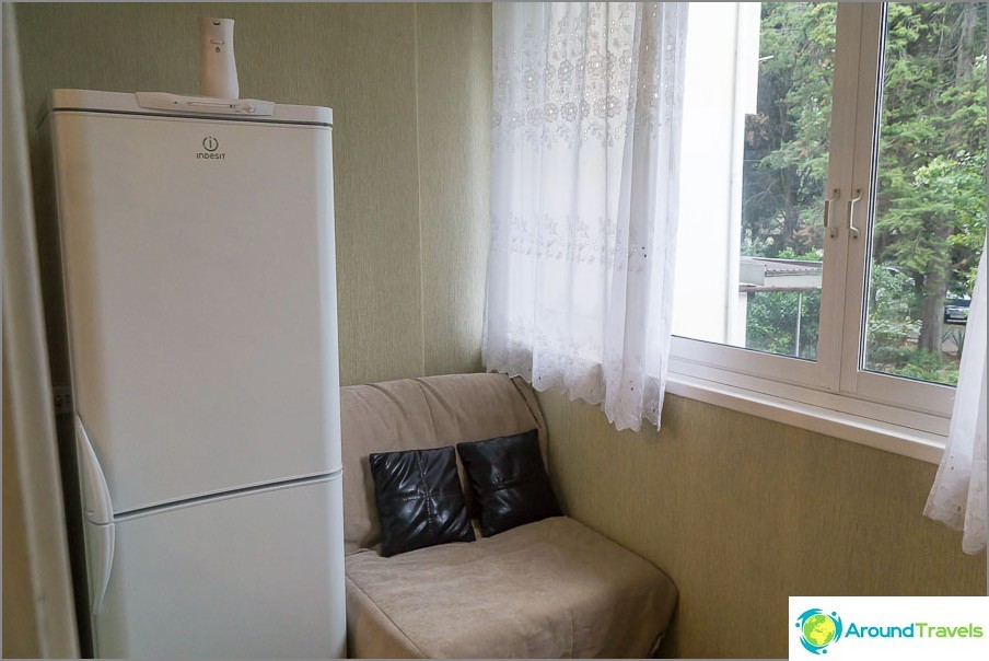 The refrigerator is on the balcony, the balcony in the room, not in the kitchen