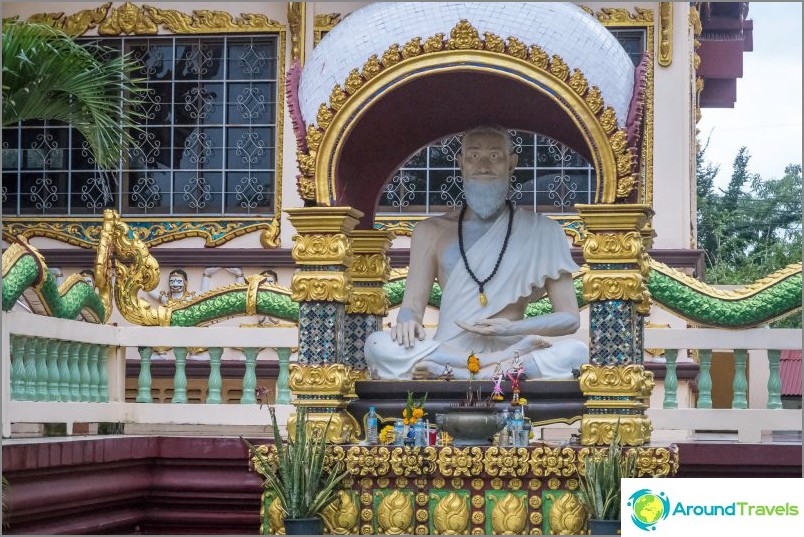 An ascetic is sitting near the temple.