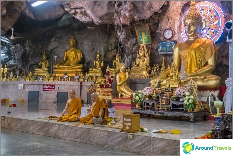 The monks are sitting in the half under the rock